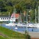 Boats docked in a marina near a small village
